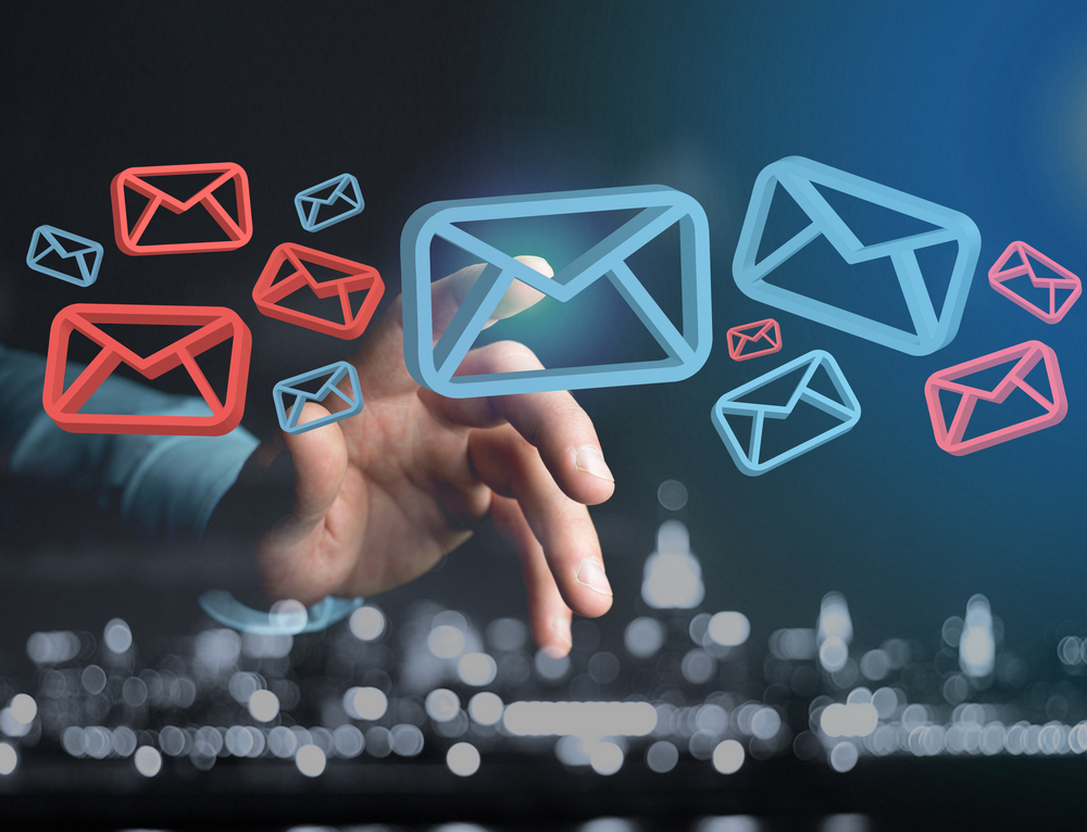 Hand selecting floating email icons, representing email compromise scam awareness and phishing risk.