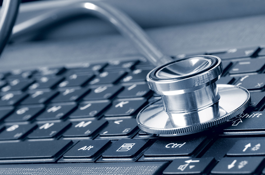 Stethoscope resting on a computer keyboard representing healthcare IT support and diagnostics.
