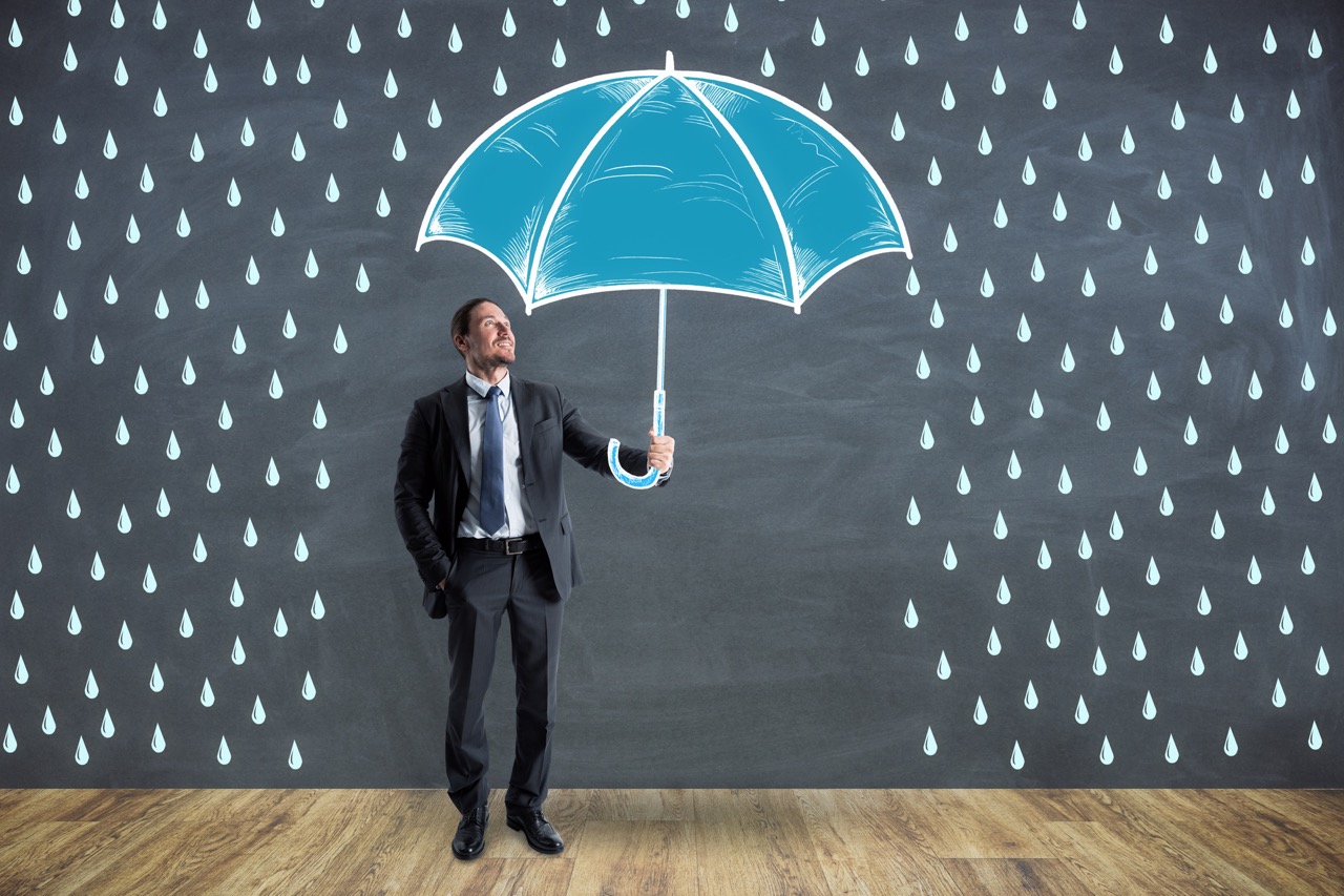 Businessman holding an umbrella under illustrated rain, representing cybersecurity and natural disaster protection.