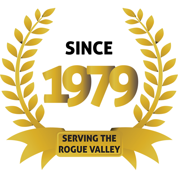 Gold laurel wreath surrounding the text “Since 1979” with a gold ribbon at the bottom that reads “Serving the Rogue Valley.”