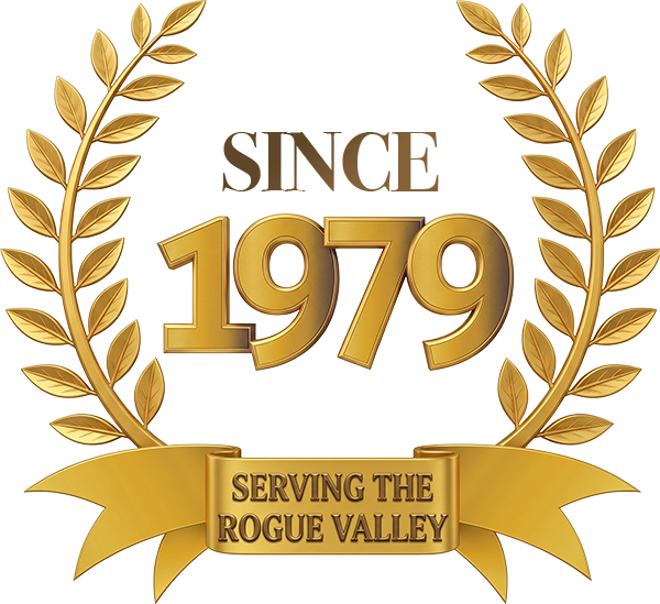 Gold laurel wreath with the text “Since 1979” and “Serving the Rogue Valley” in a ribbon banner.